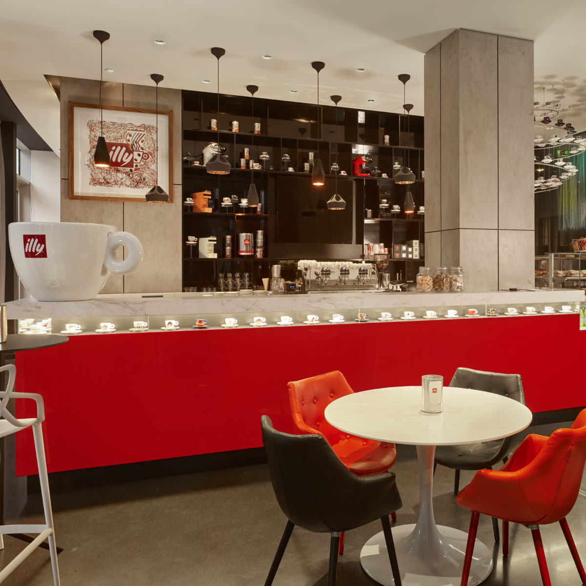 Interior shot of illy cafe with a red bar with tea pots decorating it