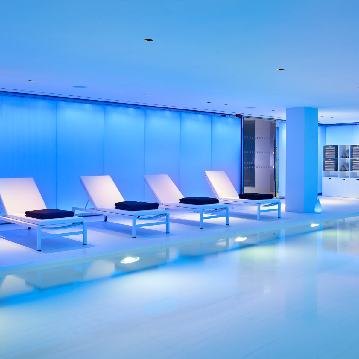 15 metre indoor heated swimming pool with step access and four lounge chairs