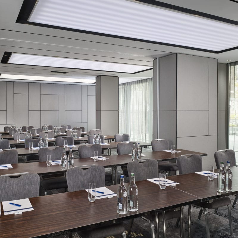 Brown tables and placed in rows with grey chairs all the way along