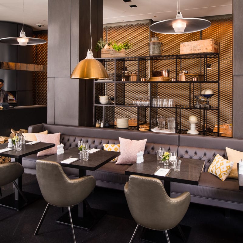 Tables in Florentine Restaurant with a bookshelf in front of a warm orange glow