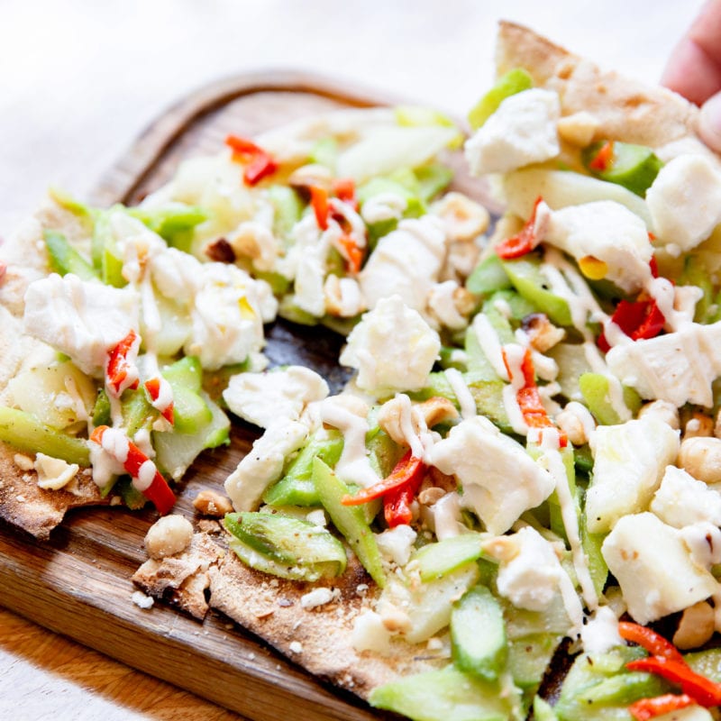 A flatbread topped with bright green asparagus, tahini, pine nuts and fresh goats cheese