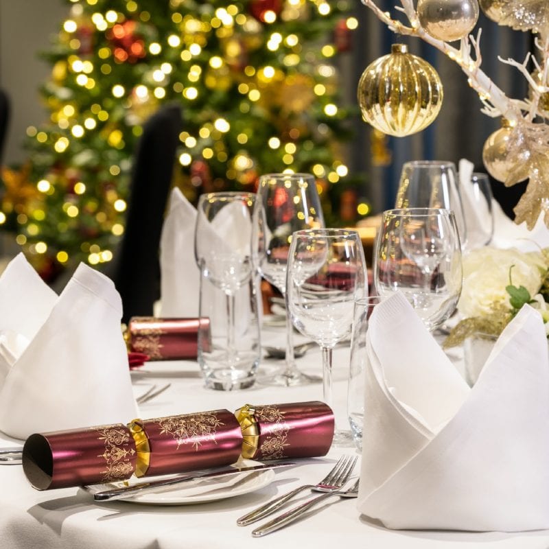 The meeting and events set up with red crackers and a white tree with gold baubles